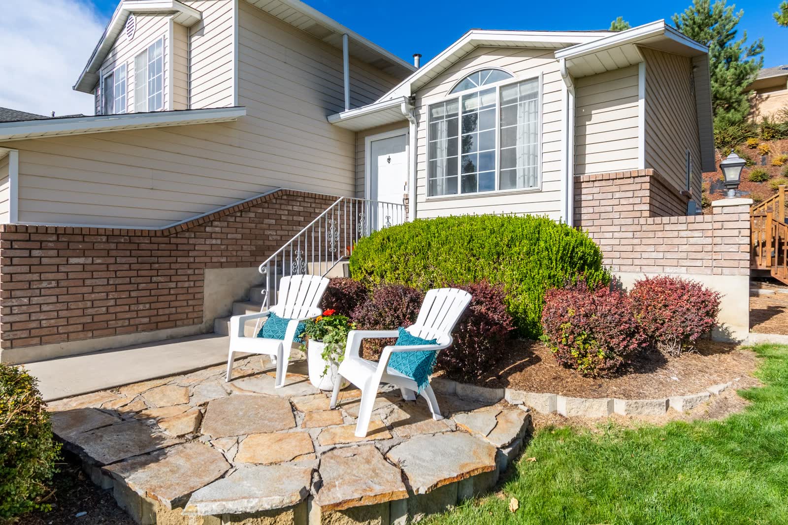 A finished stone patio with a seating area beside a lawn